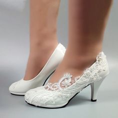 a woman wearing white high heels with lace on them