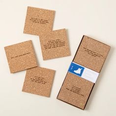 four cork coasters sitting on top of each other with a blue and white tag