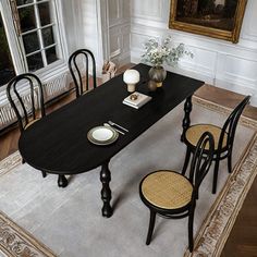 a dining room table with chairs and plates on it