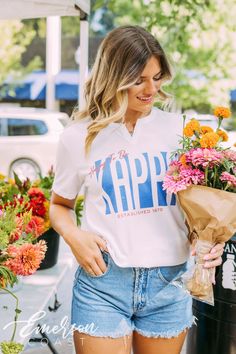 Looking for a trendy sorority tee that's different? 🫶🏻 This Kappa Kappa Gamma Happy to be Notch Tee is the answer! Whether you're giving this tee as a gift or treating yourself with something new, you'll be obsessed with this sorority t-shirt! 🌊 YOU'LL LOVE THIS STYLE 🌊 Meet the Kappa Kappa Gamma Happy to be Notch Tee - the ultimate twist on the classic white t-shirt! Our notch tee features a unique v-neck notch at the neckline, perfect for layering your favorite necklaces. The lightweight, Preppy Short Sleeve T-shirt For Spring, Spring Preppy Short Sleeve T-shirt, Sorority Short Sleeve Tops For Spring, Sorority Style Short Sleeve Tops For Spring, Short Sleeve Sorority Tops For Spring, Spring Sorority Short Sleeve Tops, Sorority Graphic Print Tops For College, Sorority Style Letter Print Tops For College, Sorority Letter Print Tops For College