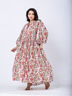 Designed with the freedom to flow with ease ~Our signature Buta Floral Dress in a palette of florals and Sumac spice. Handmade using the traditional method of block printing,an Indian artistry that has been passed down through generations.Her billowed sleeves and full flowing skirt reminisce with the magic of golden hues and sunset haze. Lovingly made with gratitude for our beautiful Mother Earth. Size: Waist :  S - M  : 90 cms Round ( fits upto uk 12) M - L.  : 100 cms Round ( fits upto uk 16) Pink Floral Print Dress With Relaxed Fit, Traditional Floral Print Midi Dress For Spring, Pink Floral Cotton Midi Dress, Traditional Spring Midi Dress With Floral Print, Relaxed Fit Cotton Midi Dress With Floral Print, Pink V-neck Dresses With Printed Motifs, Pink Cotton Dress With Kalamkari Print, Multicolor Cotton Floral Dress Bohemian Style, Multicolor Cotton Bohemian Floral Dress