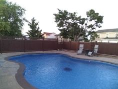 an empty swimming pool surrounded by a wooden fence