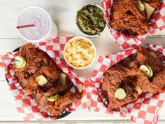 three baskets filled with different types of food on top of a white wooden table next to bowls of dips and condiments