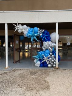 a bunch of balloons that are sitting in the ground near a building with some snowflakes on it