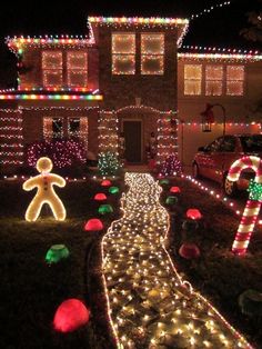 christmas lights decorate the front yard of a house in this suburban neighborhood, with a gingerbread man and candy canes