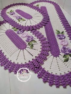 two crocheted doily with purple flowers and leaves on the edges, one has an umbrella