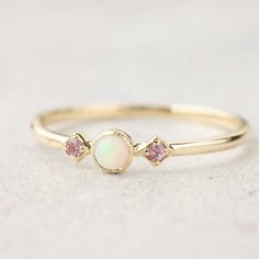 "Three stone opal and the pink sapphire ring is called \"Star and Moon Ring\", made in 100% recycled solid 14k gold featuring 3mm Australian white opal accented with pink sapphires on both sides. This unique ring is inspired by vintage art deco style ring, it is very lightweight and comfortable on your finger. Opal is known as the gem of brilliance and mystery. It is the birthstone for the month of October so it will make a unique birthday gift for October babies. Opal is a soft stone, please be Pink Sapphire Band, October Birthstone Jewelry, Star And Moon, Zierlicher Ring, Pink Sapphire Ring, Engagement Ring White Gold, Moon Ring, Blue Sapphire Rings, October Birth Stone