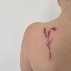 the back of a woman's shoulder with flowers tattooed on her left arm and chest