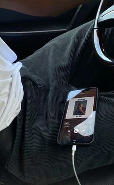 a cell phone is plugged into the charger in someone's car seat