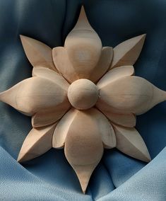 a large wooden flower sitting on top of a blue cloth