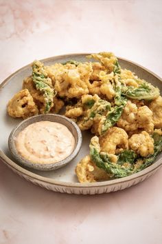 a plate full of fried food with dipping sauce