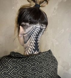 the back of a woman's head with an intricate design on her face and neck