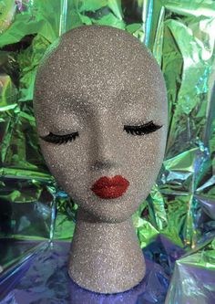 a white mannequin head with red lipstick on it