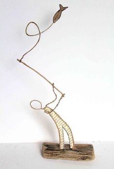 a sculpture made out of wood and wire with a bird on it's head