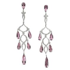 A pair of modern, morganite and diamond chandelier earrings, each earring compromising a pear-cut morganite suspending a diamond set drop in the form of two entwined ribbons and a further five pear-cut morganites, mounted in 18ct white gold, estimated total morganite weight 23.25ct, estimated total diamond weight 2.02ct. The drop measures approximately 10.5cm. Morganite Jewelry, Pearl Chandelier Earrings, Diamond Chandelier Earrings, Diamond Chandelier, Pink Sapphire Earrings, Pink Emerald, Gold Chandelier Earrings, Cocktail Earrings, Morganite Diamond