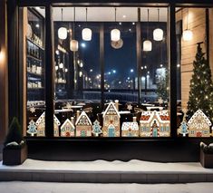 a window display with gingerbread houses and christmas trees