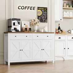 a coffee shop with white cabinets and wood flooring in the middle of an empty room