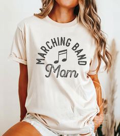 Marching Band Shirt, Band Mom Shirt, High School Band Tshirt, Marching Band Gift, Halftime Show TShirt, Drumline Shirt, Music Mom Tee Comfort Colors 1717:  T-Shirt Sizing The Comfort Colors 1717 is a relaxed fit shirt.  Please reference the size chart before selecting shirt size.  To achieve an oversized t-shirt dress look, we recommend sizing up two sizes. T-Shirt Materials: -  100% ring-spun cotton with a medium fabric. -  Soft-wash feel. -  Pre-shrunk fabric for size retention. -  Crew neck l Spring Band Merch Tops With Band Logo, Spring Music-themed Crew Neck T-shirt, Spring Band Logo Merch Tops, Spring Band Logo Tops, Music-themed Screen Print Top For Concerts, Spring Cotton Tops With Music-themed Style, Spring Music-themed Cotton Tops, Music-themed Band Logo Tops With Short Sleeves, Cotton Band Merch Shirt For Concerts