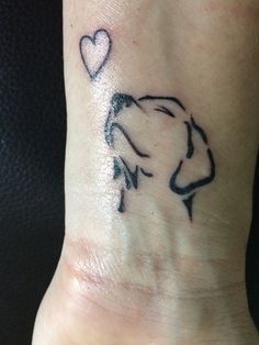 a small tattoo on the wrist of a person with a heart and arrow in it