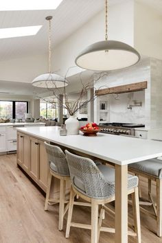 a kitchen with an island and chairs in it