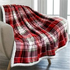 a red and white plaid blanket sitting on top of a couch