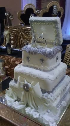 a three tiered white wedding cake on top of a glass table in front of a mirror