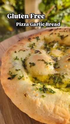 a pizza sitting on top of a wooden cutting board covered in cheese and pesto