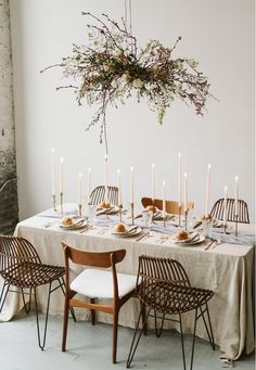 the table is set with candles, plates and napkins for an elegant dinner party