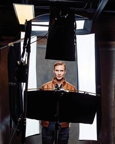 a man is standing in front of a camera and lighting equipment for a photo shoot