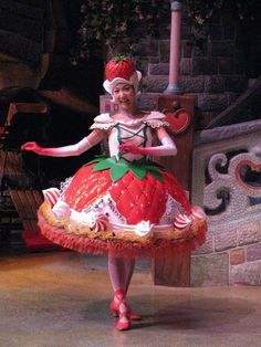 a woman in a red and white dress is dancing