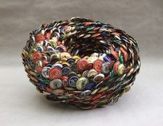 a close up of a bowl made out of many different types of buttons on a white surface