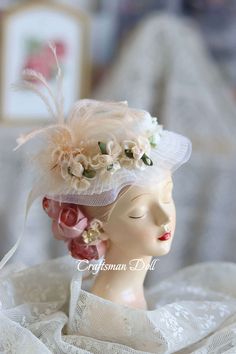 a mannequin head wearing a white hat with flowers and feathers