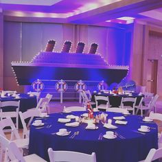 a large room with tables and chairs set up for a formal function in front of a cruise ship