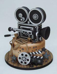 a cake made to look like an old movie camera and film reels on top