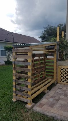 a fence made out of wooden pallets in front of a house