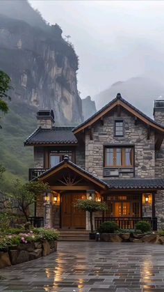 a stone house with mountains in the background and rain falling on it's roof