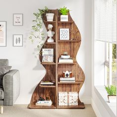 a living room filled with furniture and a book shelf next to a couch in front of a window