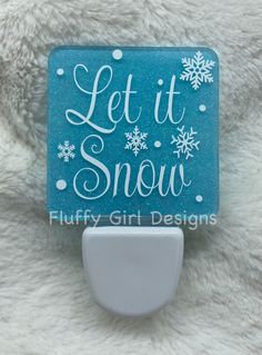 a blue and white sign that says let it snow with snowflakes on it