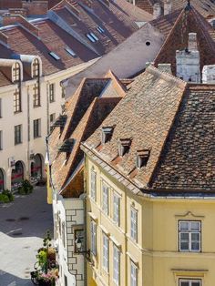 an aerial view of the roofs of buildings in a city with steeple tops and cobblestone streets