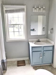 a bathroom with a sink, mirror and window