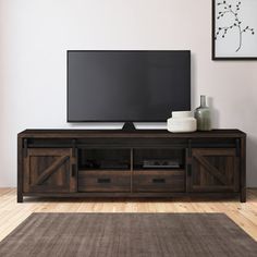 a flat screen tv sitting on top of a wooden entertainment center in a living room