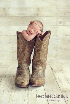 a baby sleeping in a pair of cowboy boots