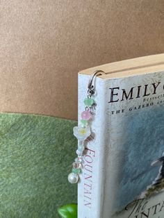 an open book sitting on top of a table next to a vase with flowers in it