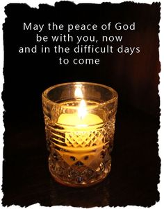 a candle that is sitting in a glass cup with the words, may the peace of god be with you, now and in the difficult days to come