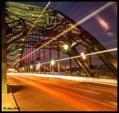 an image of a bridge that is going over the water at night time with long exposure