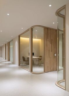 an empty room with glass walls and wooden doors in the center, leading to a meeting area