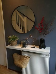 a white radiator sitting next to a wall with a round mirror on it