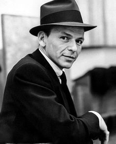 a black and white photo of a man wearing a hat