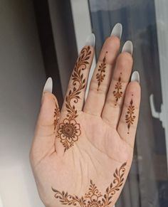 a woman's hand with hendix on it and flowers painted on the palm