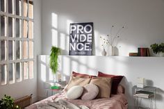 a bed sitting in a bedroom next to a window with lots of plants on top of it